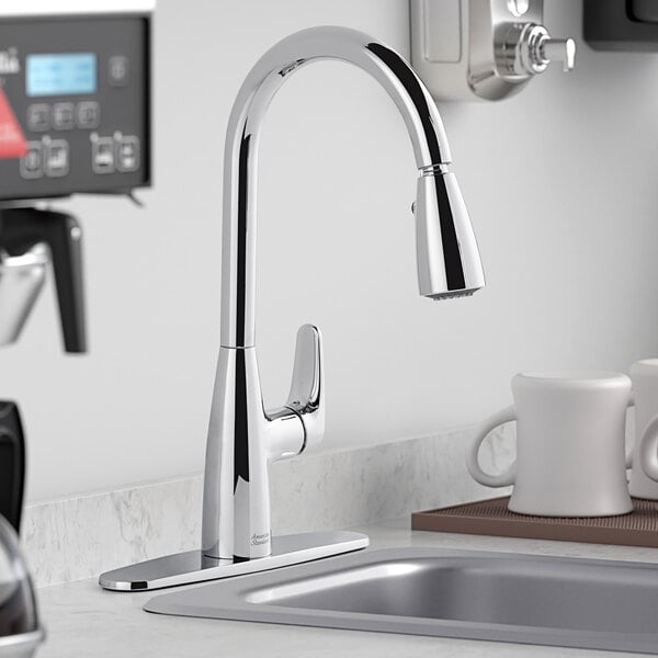 An American Standard deck-mount kitchen faucet over a sink.