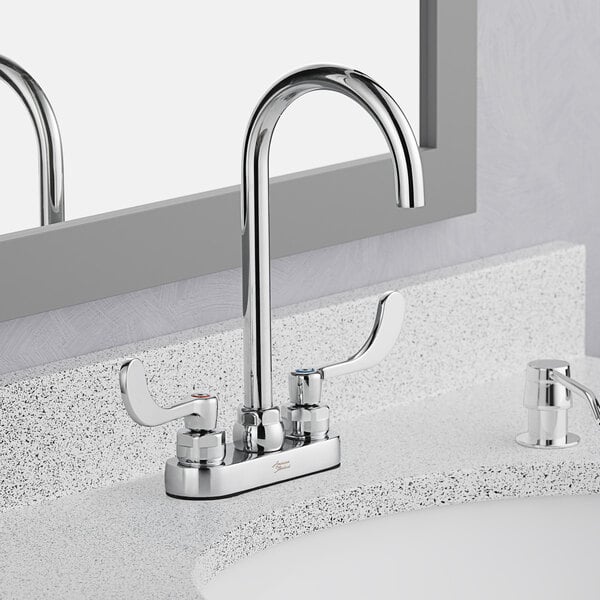 A white bathroom counter with an American Standard deck-mount faucet with wrist blade handles.