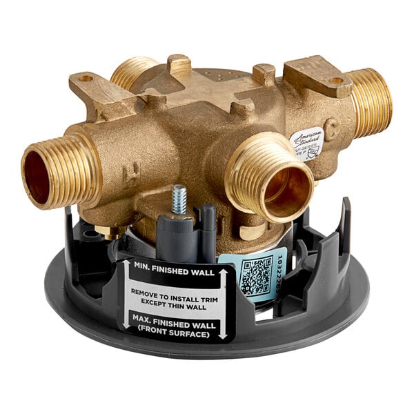 An American Standard shower valve body with gold metal and black plastic parts.