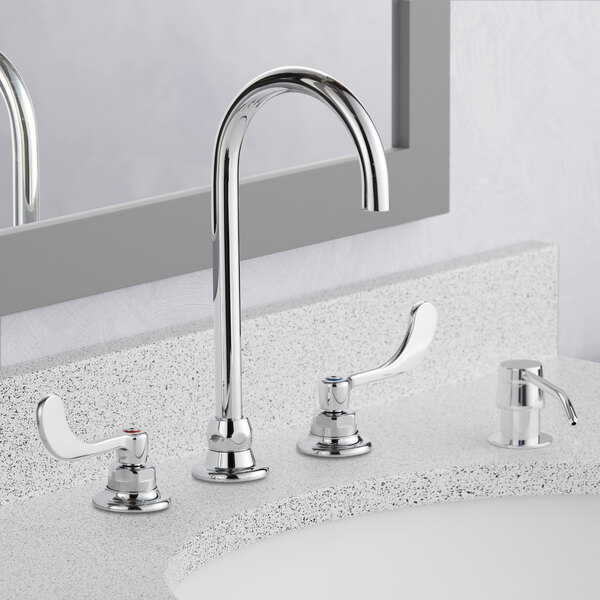 An American Standard deck-mount widespread lavatory faucet with rigid / swivel gooseneck spouts over a bathroom sink.