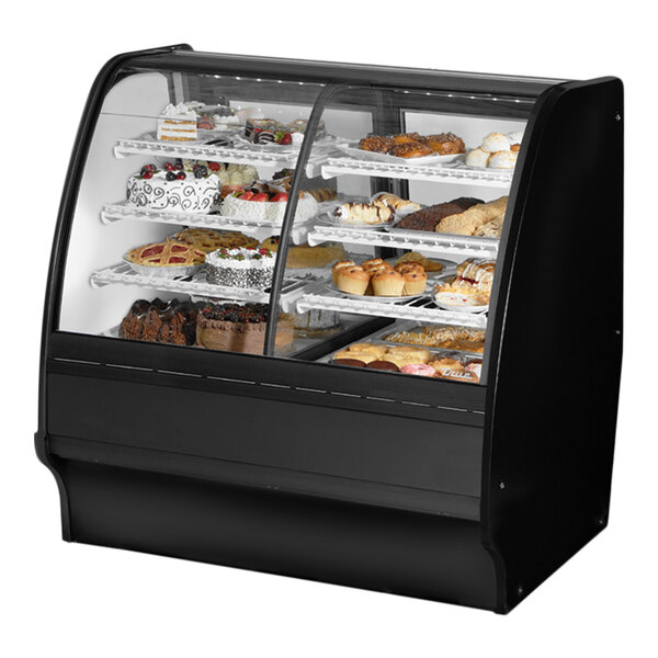 A True dual zone bakery display case with curved black glass shelves holding various pastries.