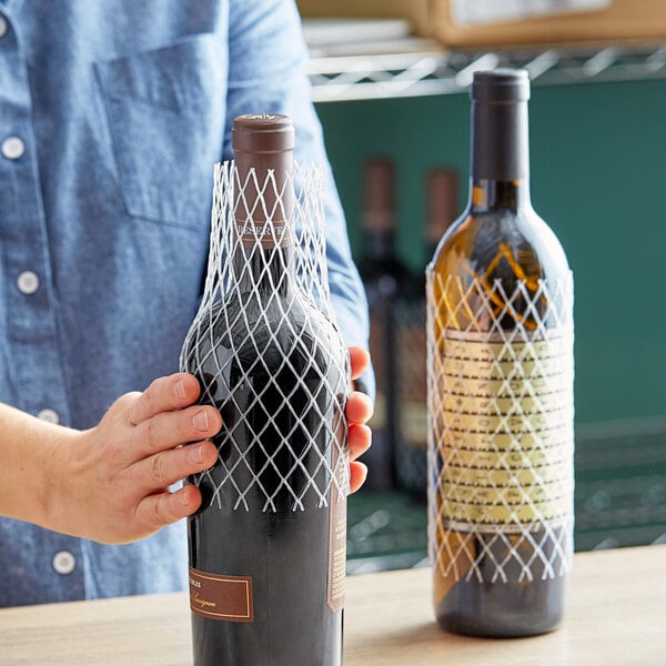 A hand holding a bottle of wine with a Franmara bottle protector sleeve.