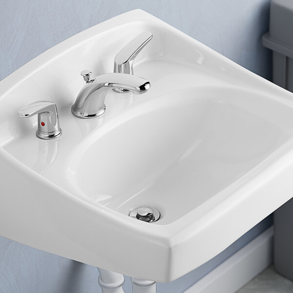 An American Standard Colony Pro deck-mount faucet with silver lever handles on a white sink.