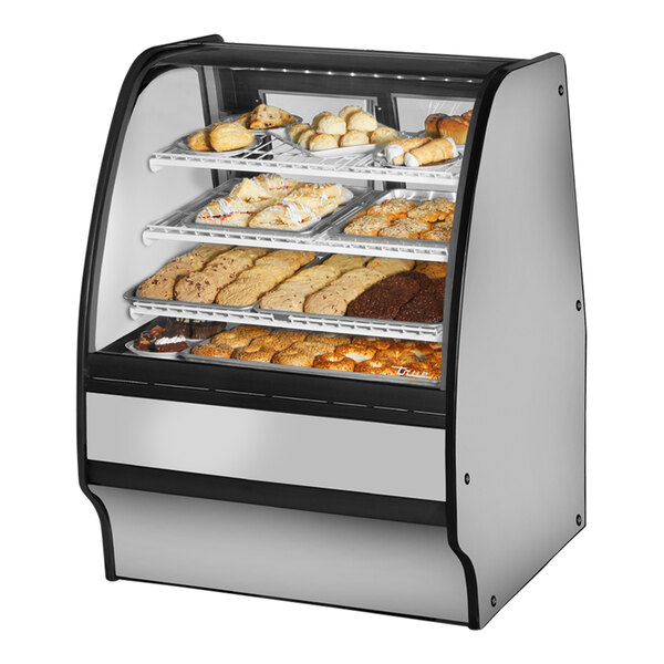 A True curved glass dry bakery display case with various types of pastries inside.