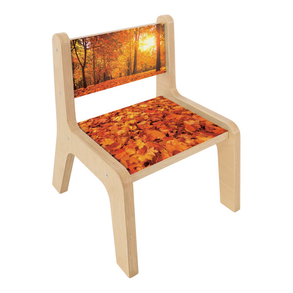 A wooden Whitney Brothers children's chair with a pattern of leaves on the seat.