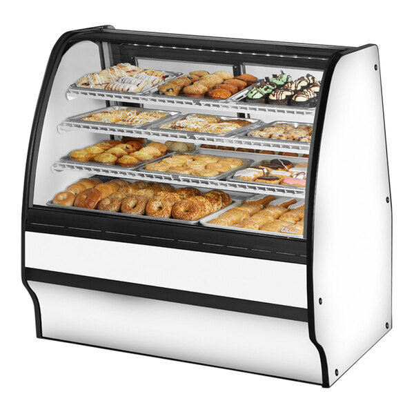 A True curved glass bakery display case with pastries inside.