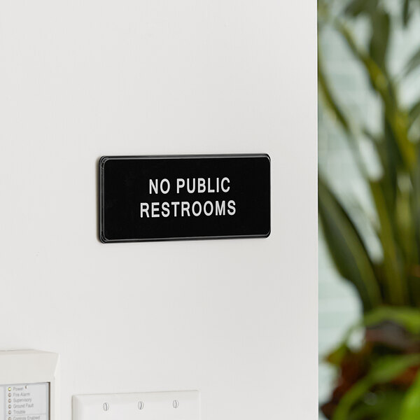 A black and white Lavex sign that says "No Public Restrooms" on a wall.