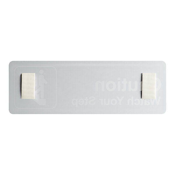 A white rectangular Lavex sign with black text that says "Caution Watch Your Step"