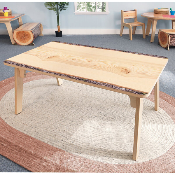 A Whitney Brothers wood table with live edge wood legs and top.