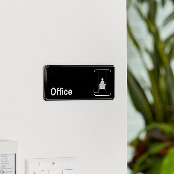 A black and white Lavex office sign on a white wall.