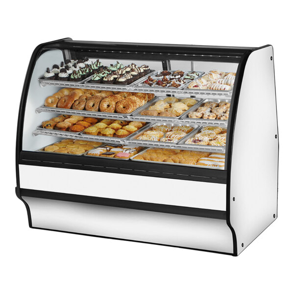 A True curved glass white dry bakery display case filled with various types of pastries.
