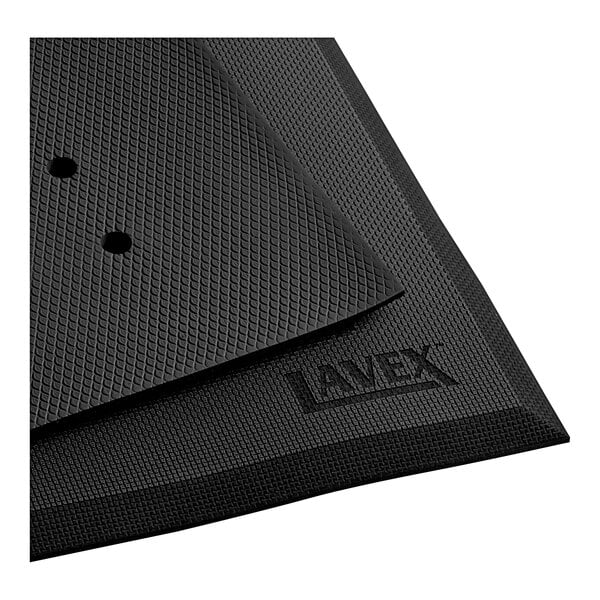 A close-up of a Lavex black anti-fatigue floor mat with drainage holes.