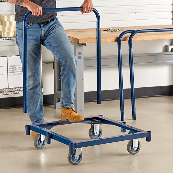 A man holding a Lavex steel panel truck with a blue handle.