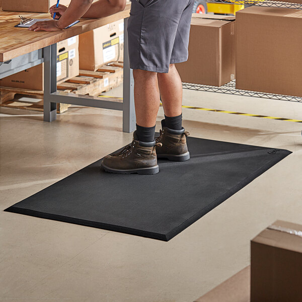 A man standing on a black Choice anti-fatigue floor mat.