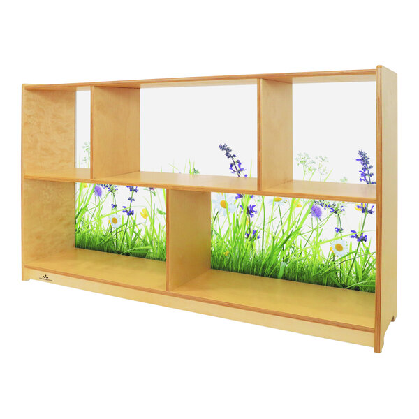 A Whitney Brothers wood cabinet with grass and flowers on the shelves.