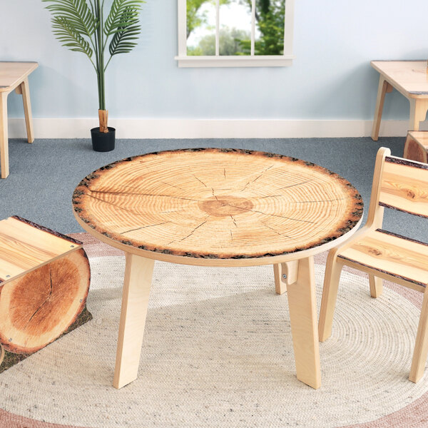 A Whitney Brothers round wooden table with live edge wood on the table top and chairs.
