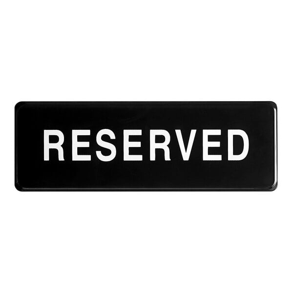 A black rectangular sign with white letters that says "Reserved"