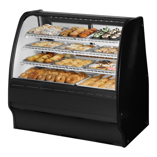 A True black curved glass dry bakery display case with various pastries inside.