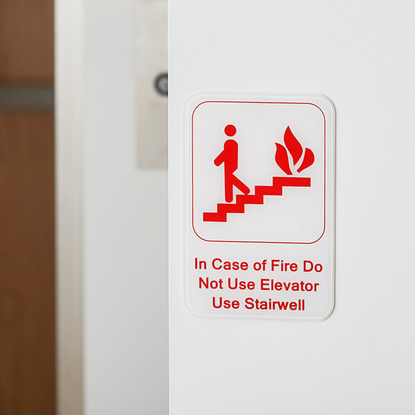A red and white wall sign that says "In Case Of A Fire Do Not Use Elevator, Use Stairwell"