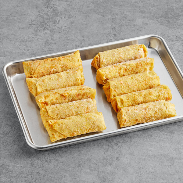 A tray with four pork egg rolls on it.
