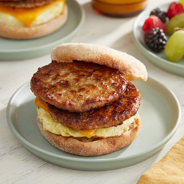 A breakfast sandwich with two Hatfield sage sausage patties on a plate.