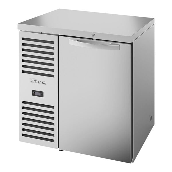 A stainless steel True back bar refrigerator with a solid door.