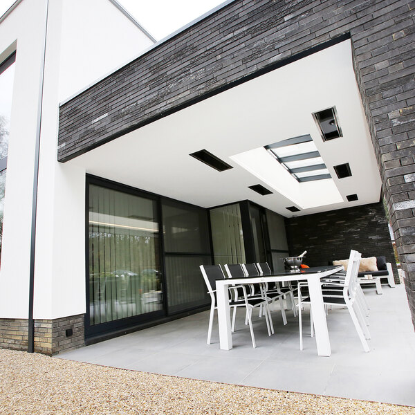 A table and chairs on a patio with a Bromic Heating ceiling recess kit above.