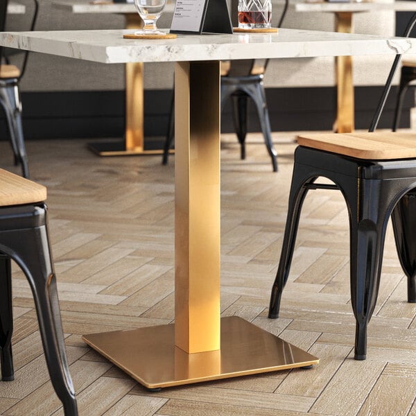 A white marble restaurant table with a gold Art Marble Furniture table base.