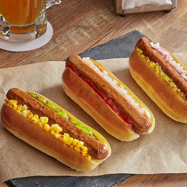 A group of Better Balance plant-based hot dogs on a table with ketchup, mustard, and onions.