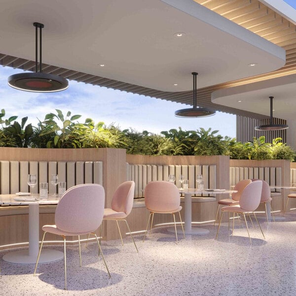 A Bromic Heating twin ceiling mount pole for Eclipse heaters above a group of pink chairs in a restaurant.