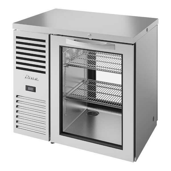 A silver True back bar refrigerator with glass doors.