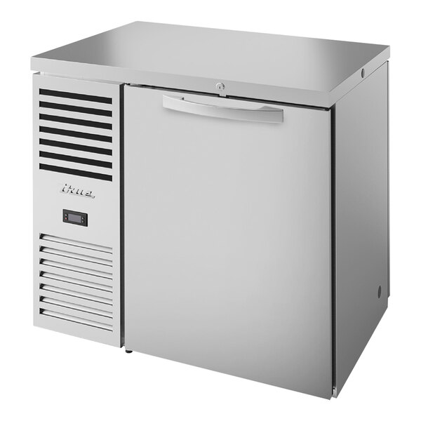 A stainless steel True back bar refrigerator with a closed door.