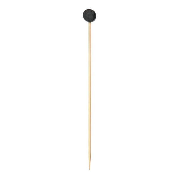 A bamboo food pick with a black hockey puck on the end.