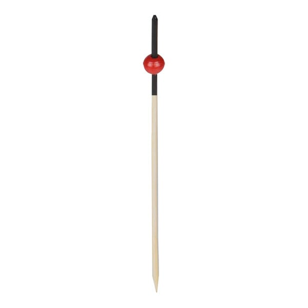 A wooden food pick with a black and red beaded end.