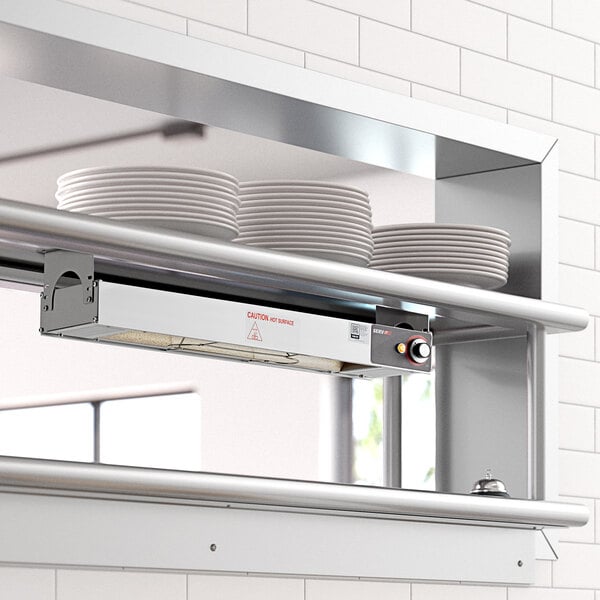 A ServIt strip warmer mounted on a kitchen shelf above a plate.