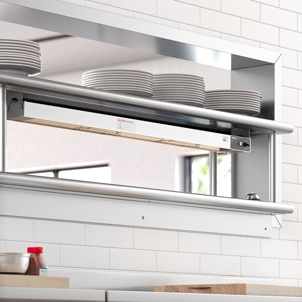 A ServIt strip warmer on a stainless steel counter in a professional kitchen.