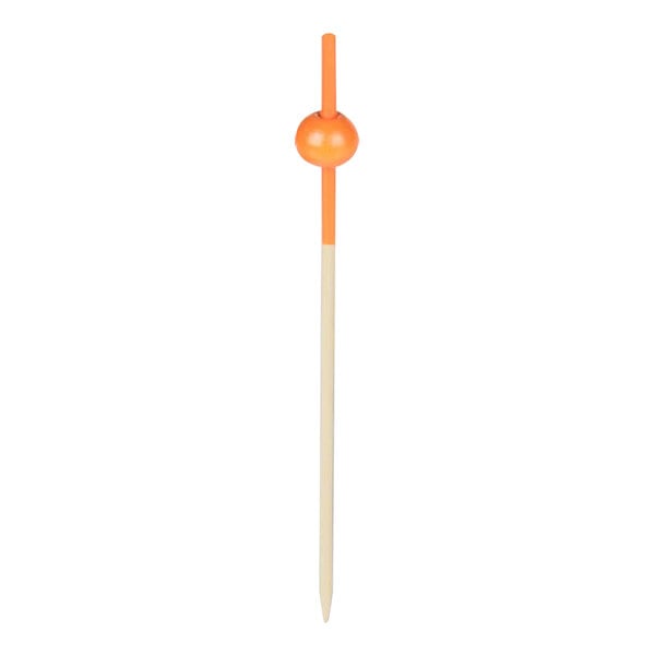 A wooden food pick with an orange beaded ball on top.