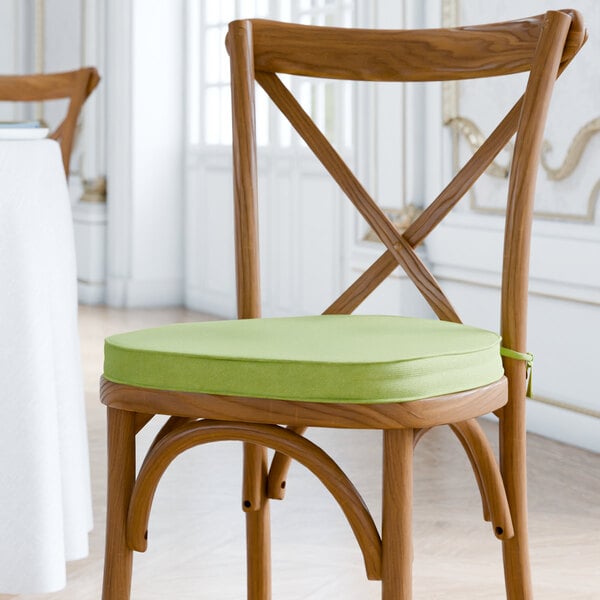 A Lancaster Table & Seating chair with a green Vineyard Series cushion with ties.