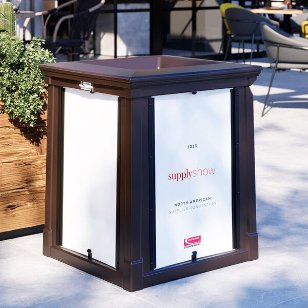 A brown Suncast outdoor waste container with open top lid and white sign frames.