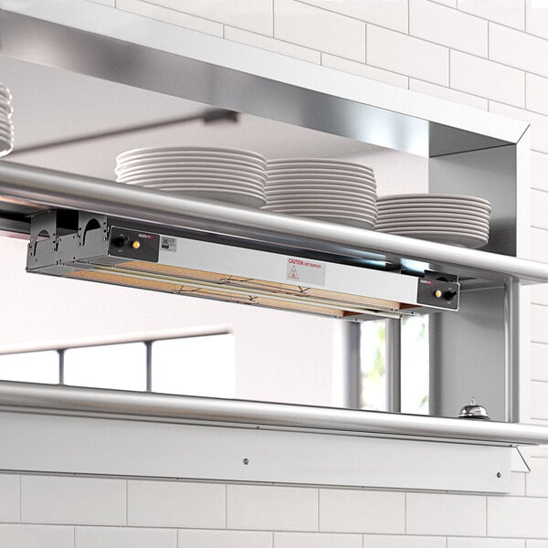 A ServIt double strip warmer on a counter with plates on the shelves.