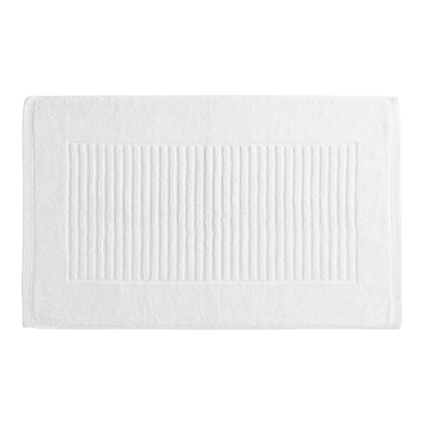 A white bath mat with a striped pattern.