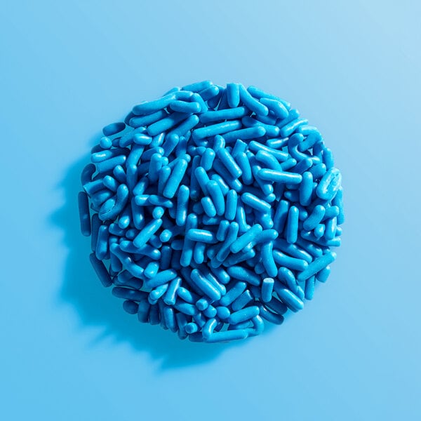 A round pile of blue sprinkles on a light blue background.
