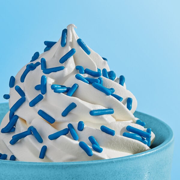 A bowl of soft serve ice cream topped with blue sprinkles.