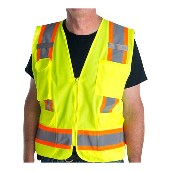 A man wearing a lime green Cordova surveyor's safety vest with reflective tape.