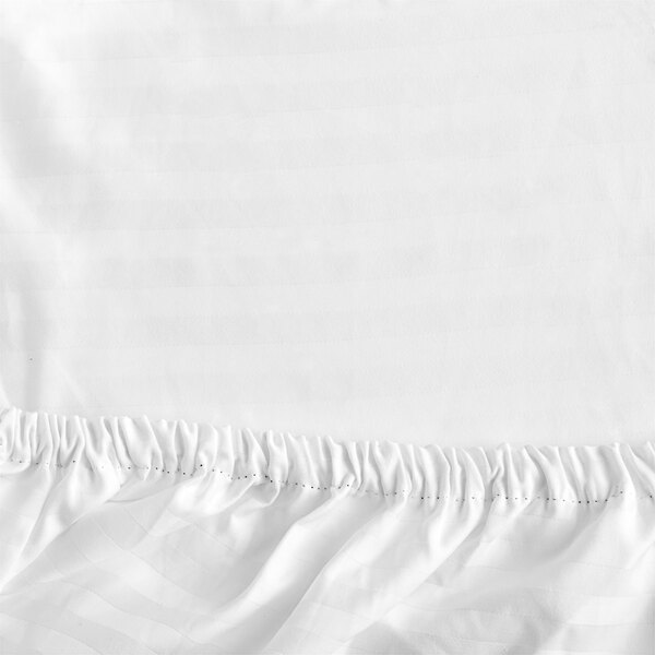 A white Garnier-Thiebaut king size fitted sheet with a ruffled edge.