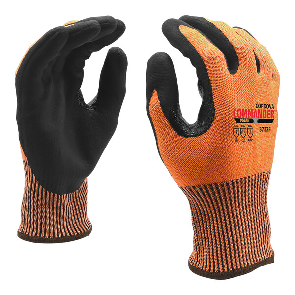 A close-up of an orange and black Cordova Commander work glove.