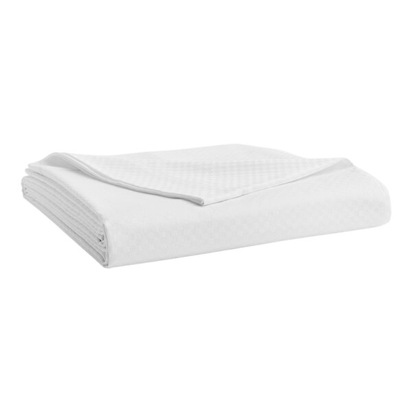 A folded white Garnier-Thiebaut Berkley micro check flat sheet on a white surface.