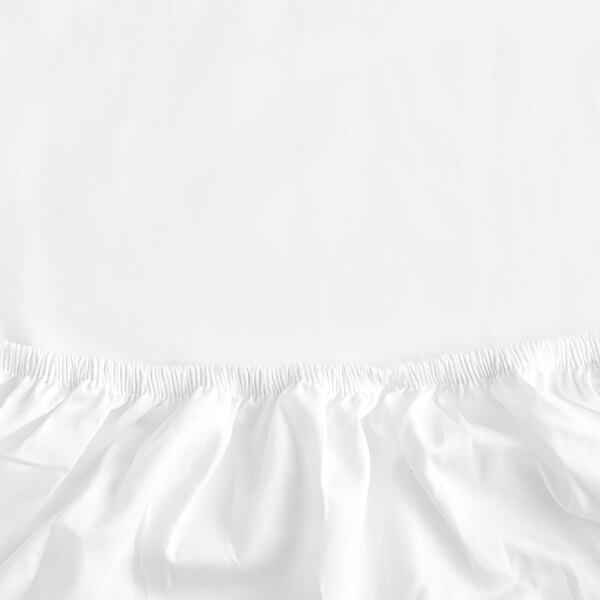 A white Garnier-Thiebaut king size fitted sheet with a ruffled edge.