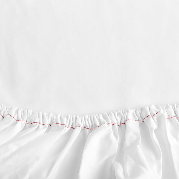 A close-up of a white Garnier-Thiebaut Georgetown fitted sheet with red thread.