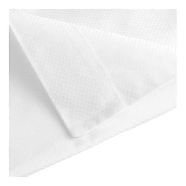 A folded white pillowcase with a checkered pattern.